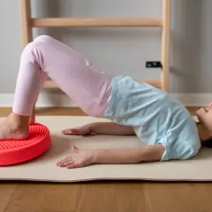 Dziecko ćwiczy na poduszce sensorycznej dla dzieci z ADHD, poprawiając równowagę i koordynację.