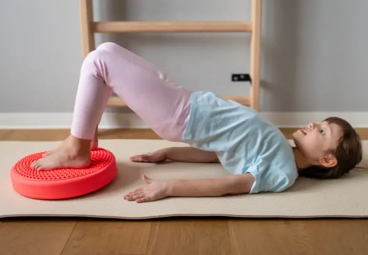 Dziecko ćwiczy na poduszce sensorycznej dla dzieci z ADHD, poprawiając równowagę i koordynację.